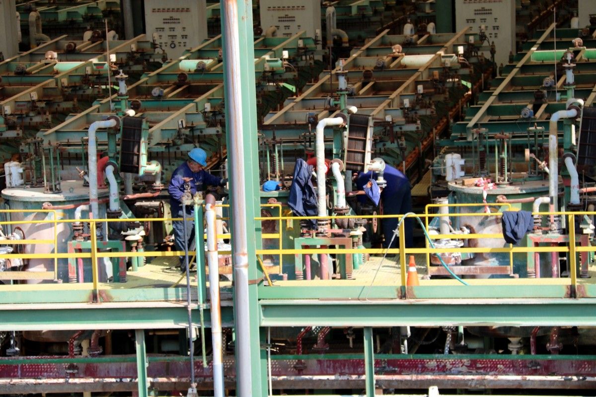 Uns treballadors operant a la planta de clor de Flix 