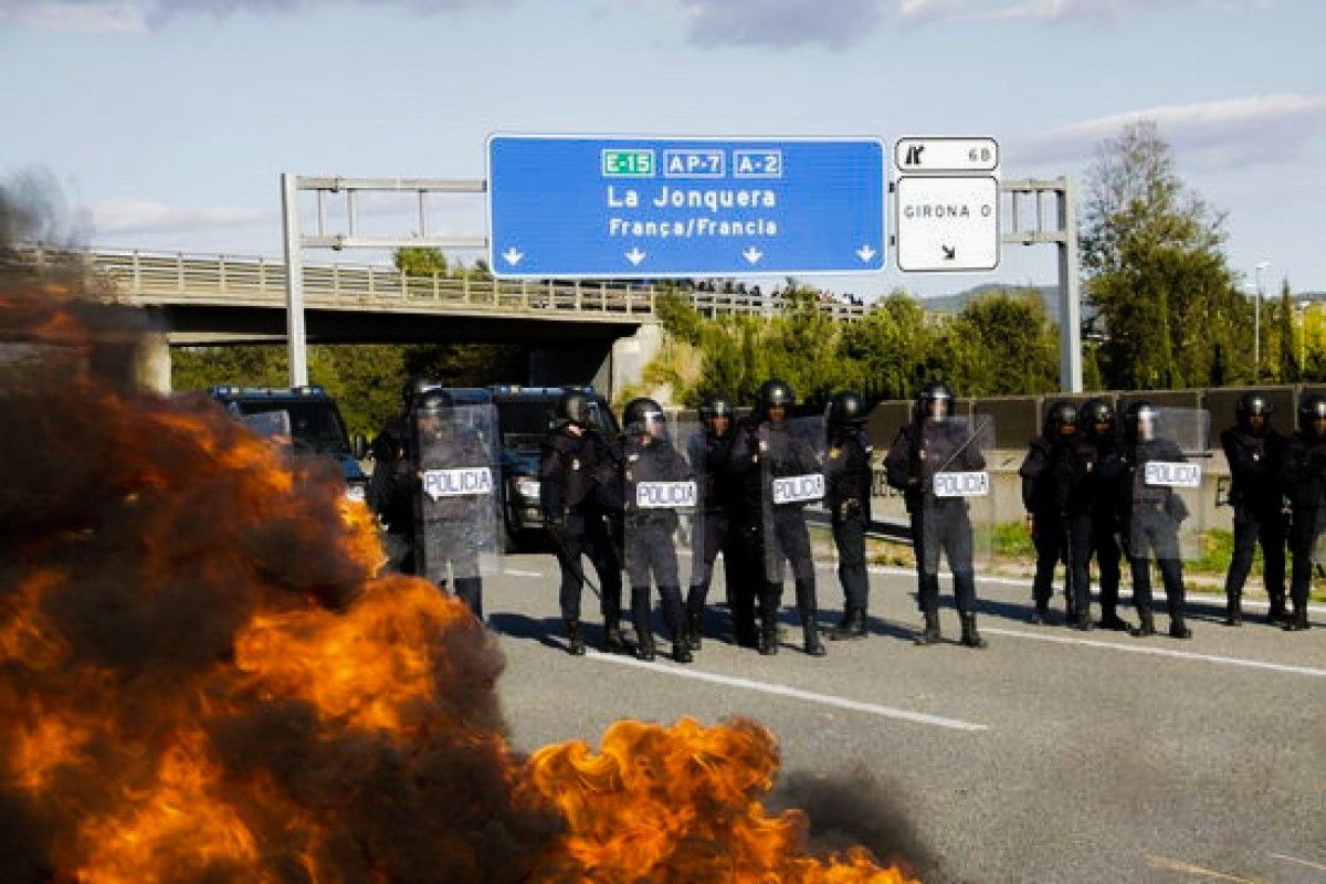 La Policia Nacional i una barricada cremant a l'AP-7 a Girona Oest, el 15 d'octubre del 2019 