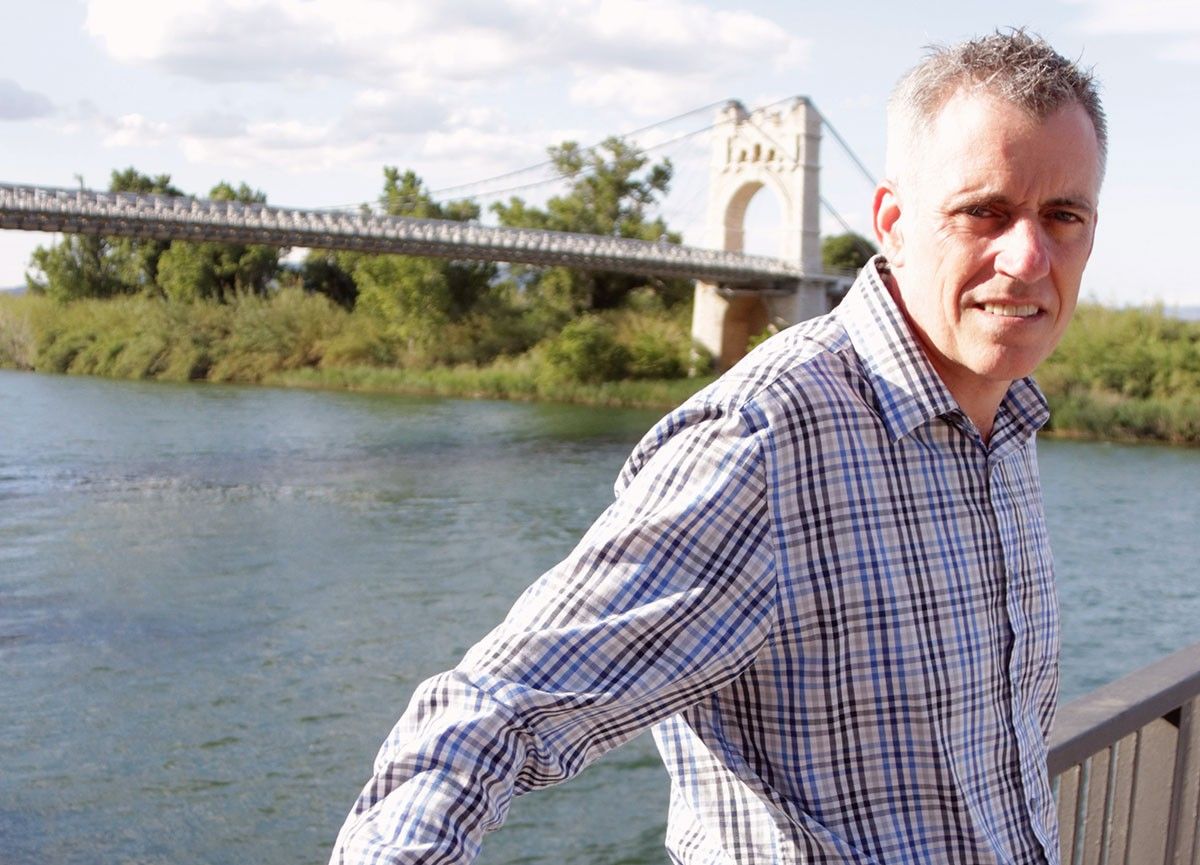 L'alcalde d'Amposta, Adam Tomàs, amb el pont penjant i el riu Ebre de fons.