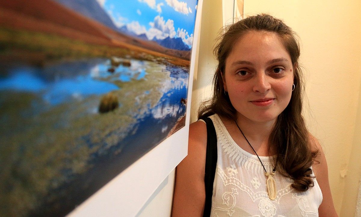 Eva Mascarell, al costat d'una de les fotos de l'exposició que complementen l'estrena del documental, 'Per què Xile'.