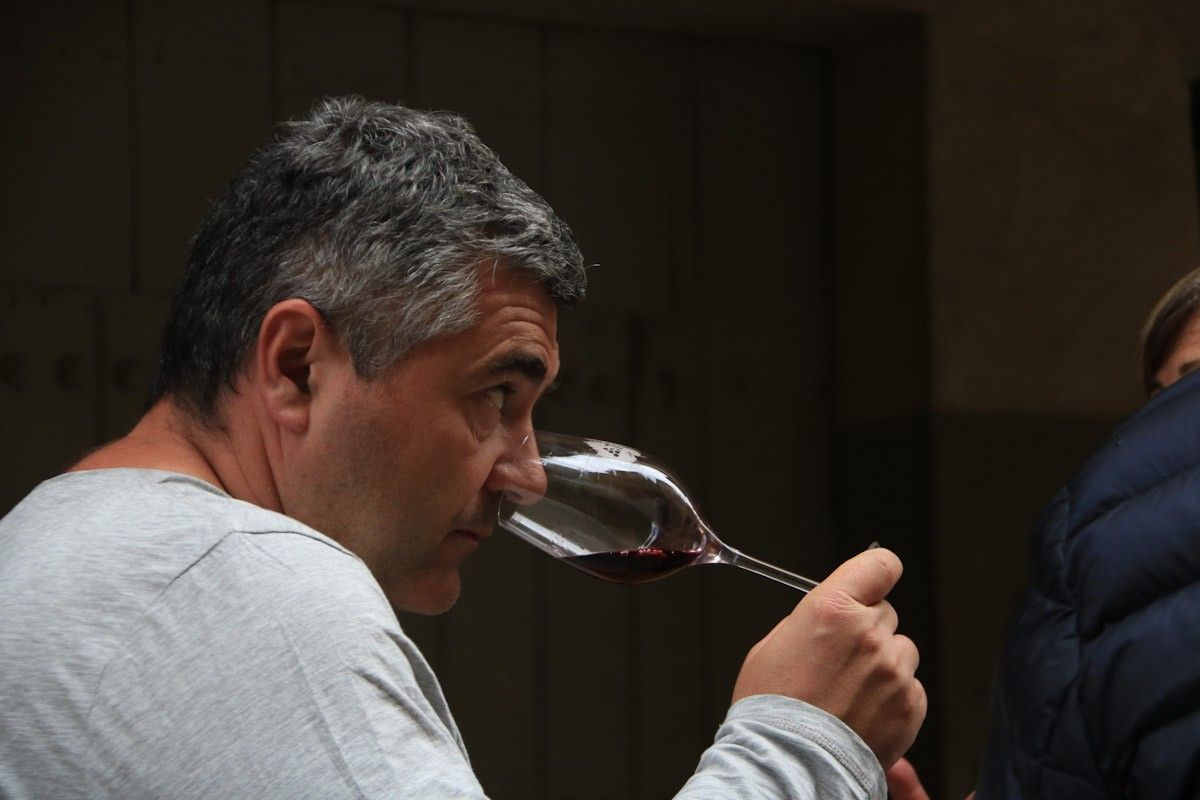 Un home olora una copa de vi de la DO Terra Alta abans de catar-lo, a la mostra de vins de Batea  