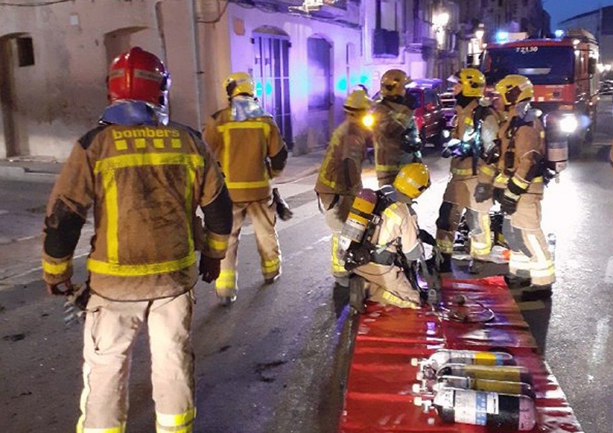 Els Bombers treballant este matí en l'incendi declarat en un pis a Tortosa.