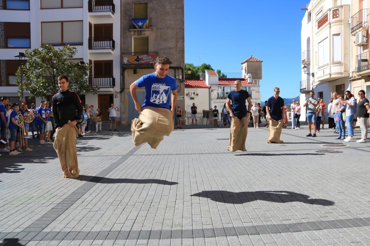 Quatre joves participen a la cursa de sacs de la primera edició de la 'Xalera' la primera jornada de joc i ball al carrer a la Sénia  