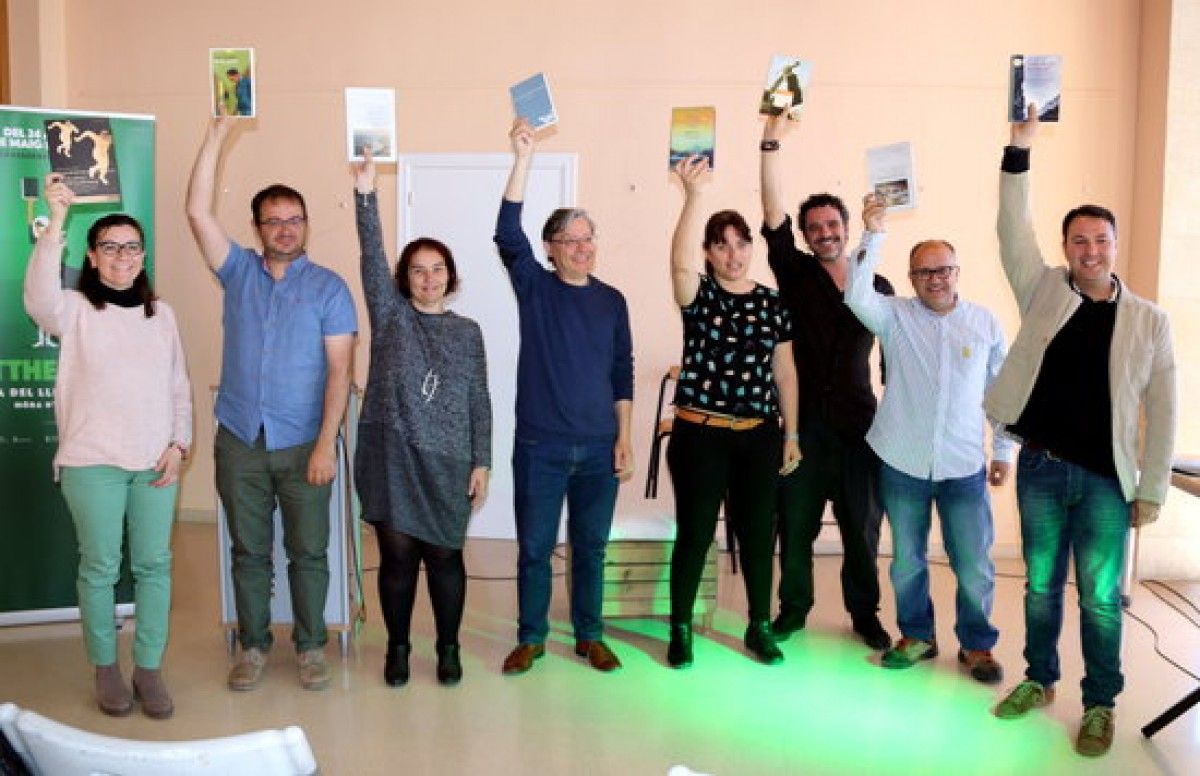 Foto de família dels directors i col·laboradors de la fira del llibre ebrenc i Litterarum de Móra d'Ebre, aixecant un llibre com els figures dels LittHerois que protagonitzen els cartells