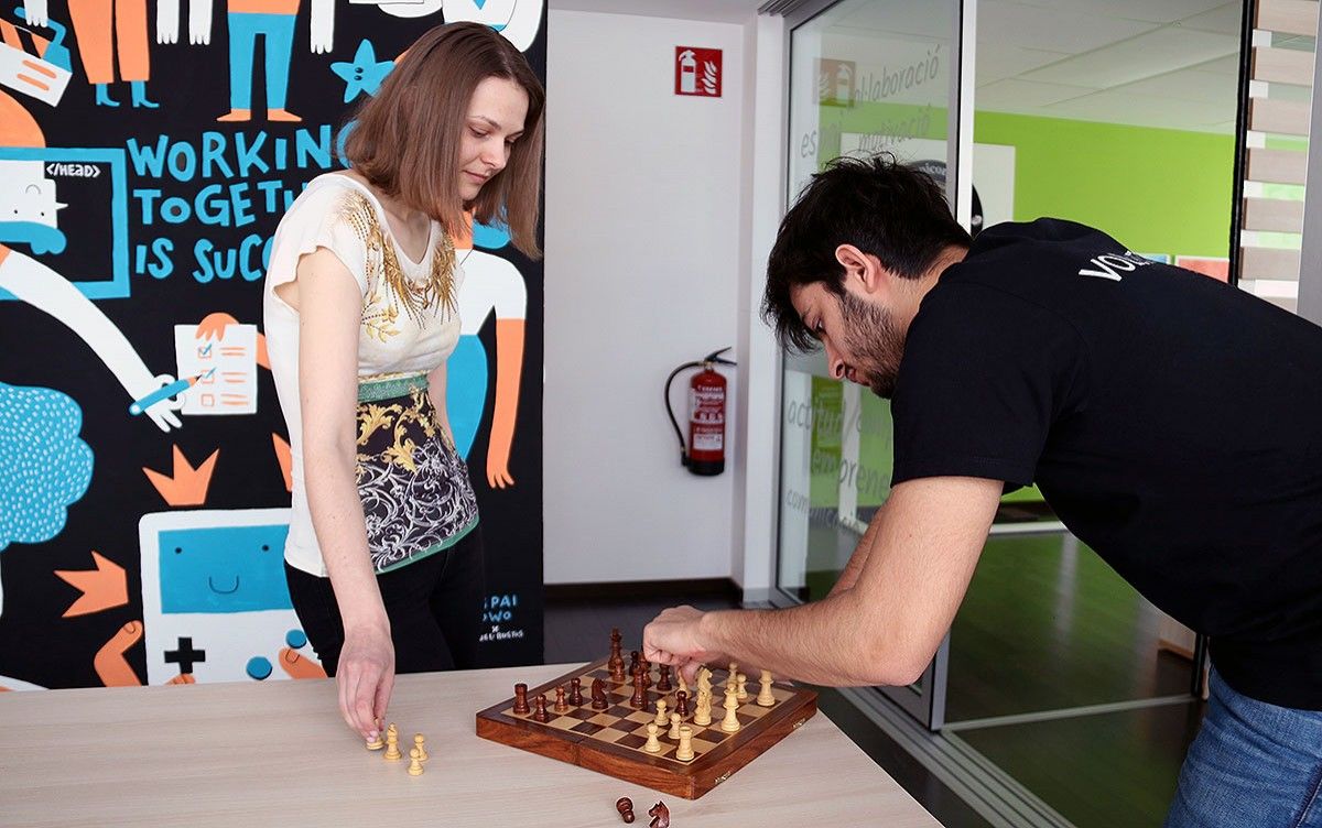 L'escaquista Anna Muzychuk jugant a escacs amb un voluntari de TEDxAmposta, a l'espai Kowo d'Amposta.