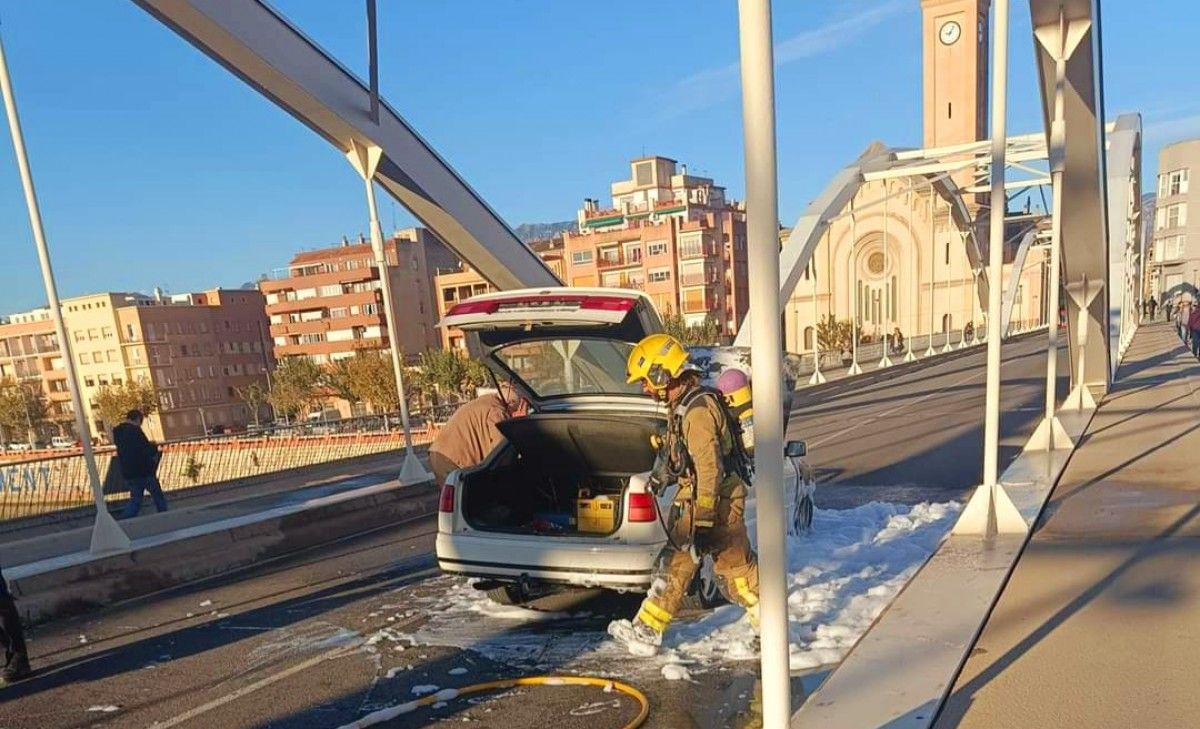 Els bombers durant les tasques d'extinció del vehicle incendiat al Pont de Tortosa 