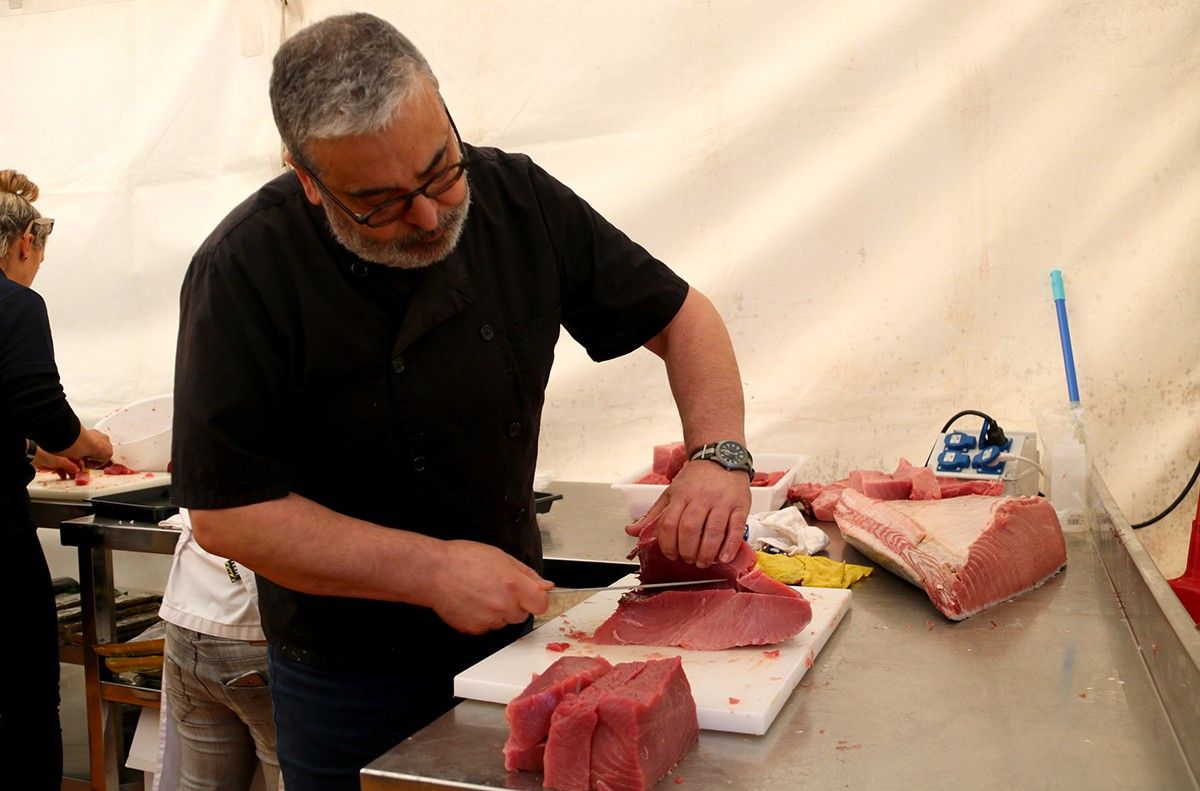 Pla mig d'un home tallant una peça de tonyina roja. Foto d'arxiu