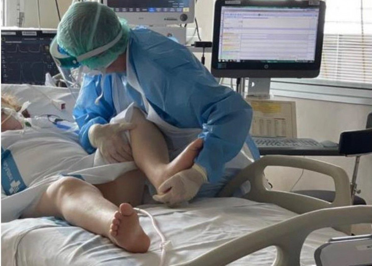 Un fisioterapeuta atenent una pacient amb Covid-19 a l'Hospital Verge de la Cinta