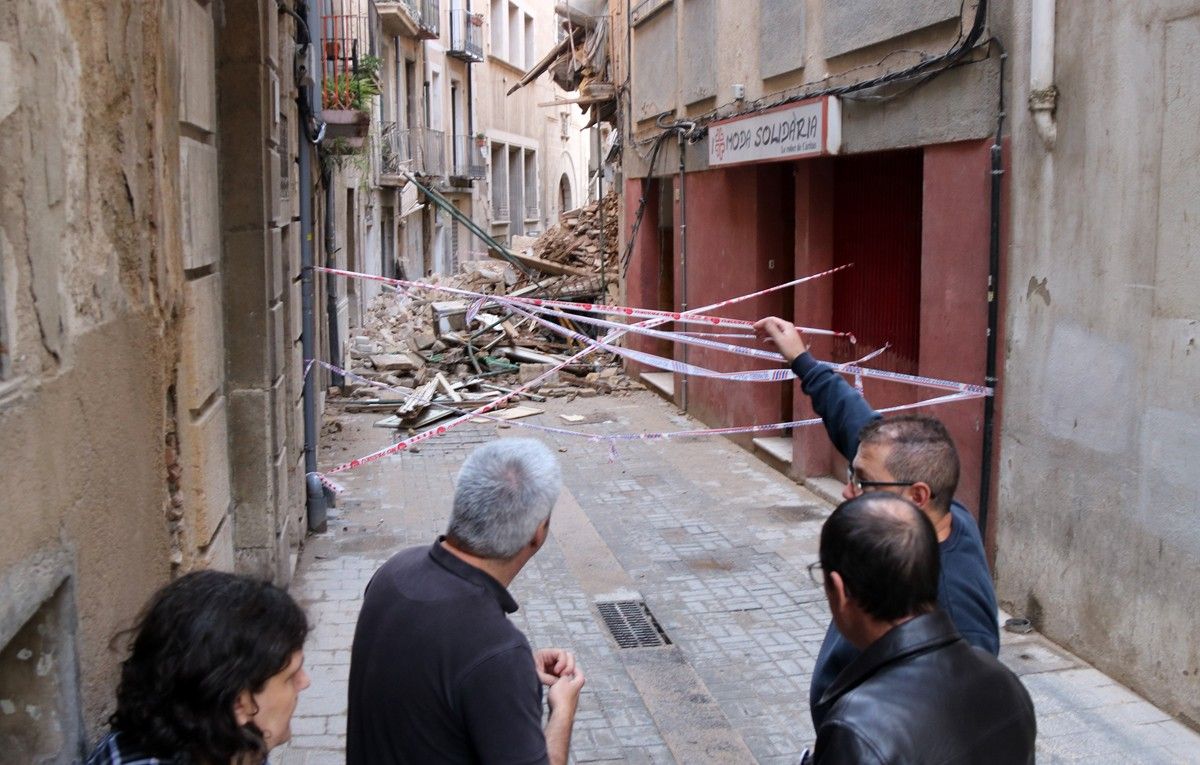 Tècnics municipals i veïns observen les destrosses al carrer Montcada.