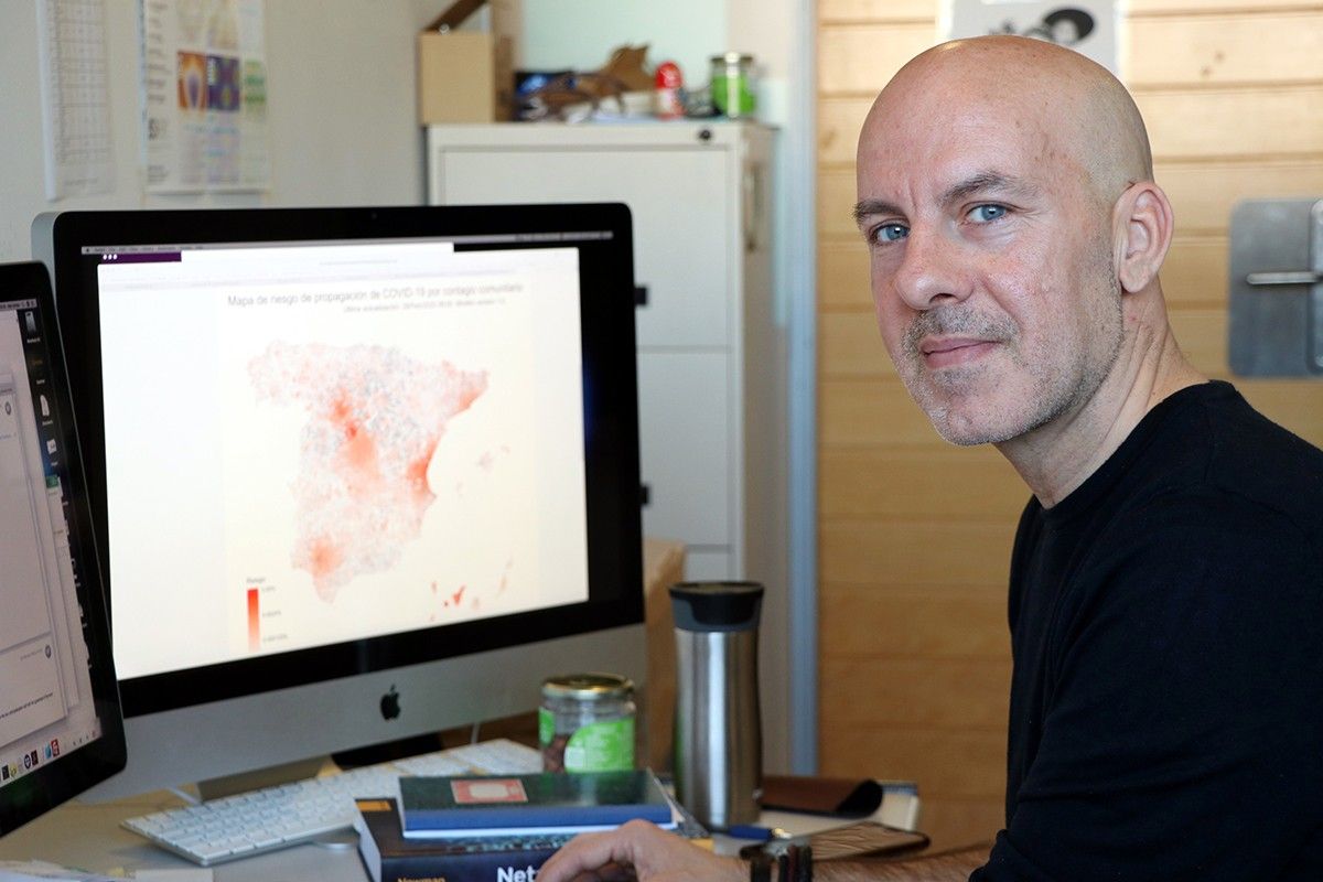 Àlex Arenas, investigador del grup de recerca Alephsys Lab de la URV, amb una pantalla al fons amb el mapa de l'estat espanyol.
