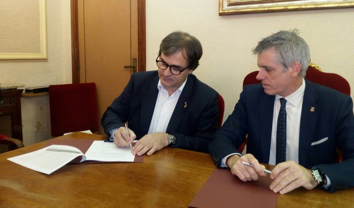El secretari d'Hàbitat Urbà i Territori, Agustí Serra, signant el conveni amb l'alcalde d'Amposta, Adam Tomàs.