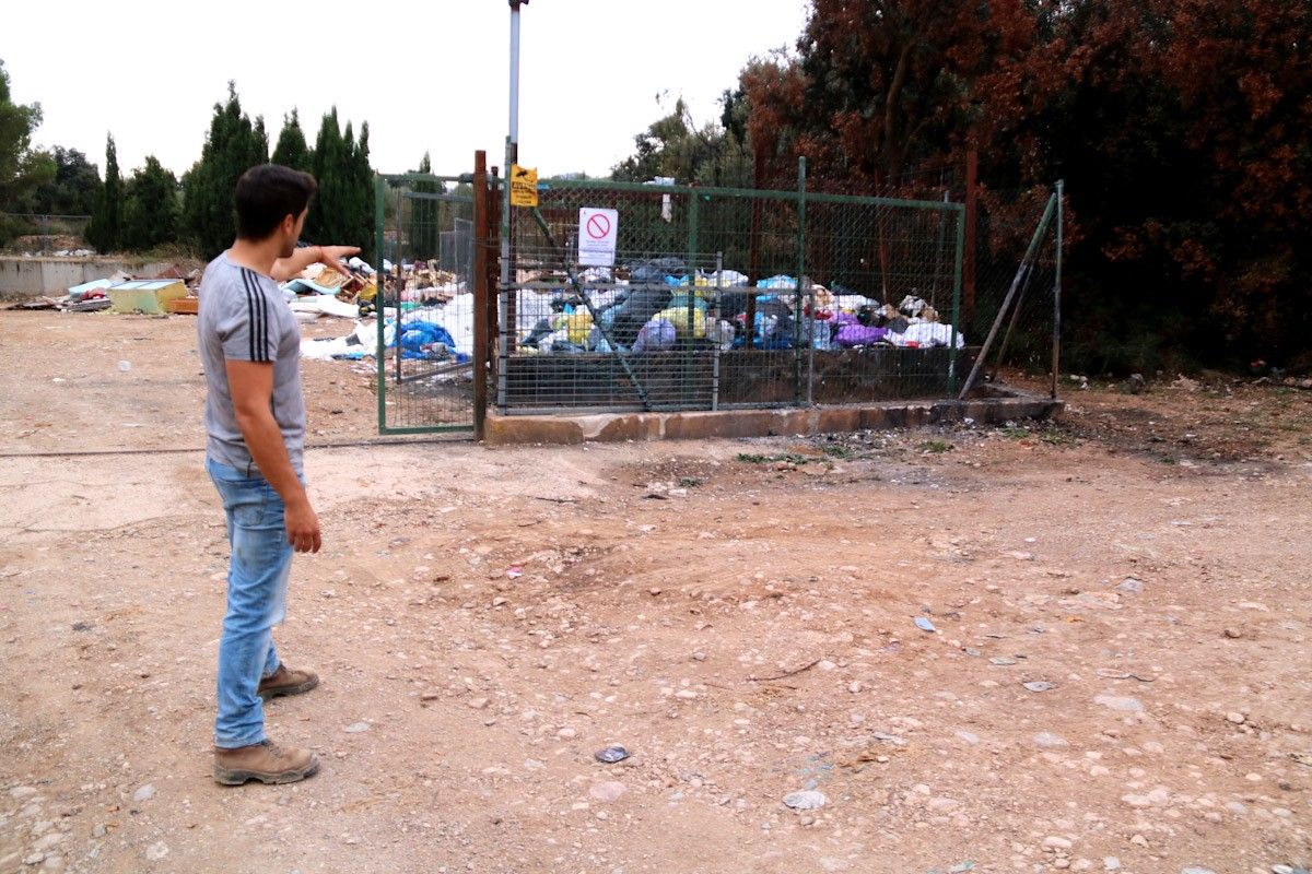 L'alcalde d'Arnes, Joaquim Miralles, assenyala la zona on els llencen bosses de brossa de manera irregular i on han situat l'avís de els càmeres de vigilància  