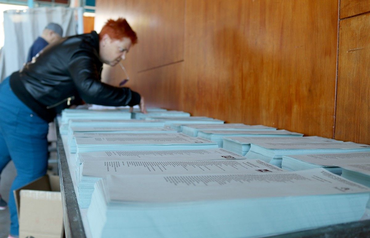 Una votant observa les paperetes de les eleccions municipals i europees