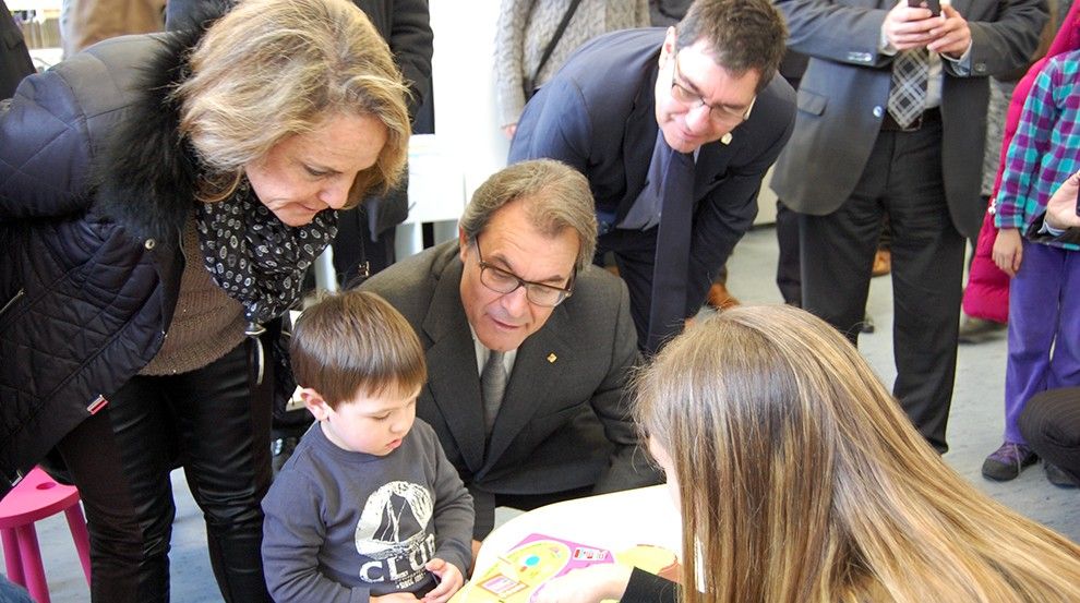 El president, Artur Mas, i la seua esposa Helena Rakosnik, han conversat amb uns xiquets a la zona infantil de la biblioteca.