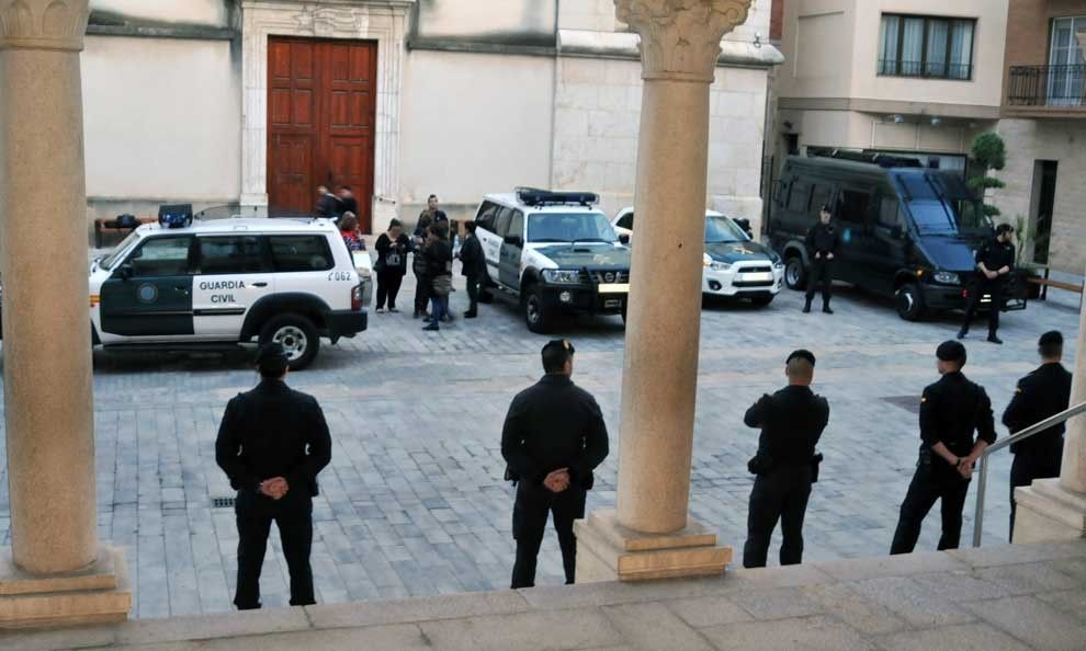 Agents de la Guàrdia Civil custodien l'entrada a l'Ajuntament. A la plaça, els vehicles de l'operatiu.