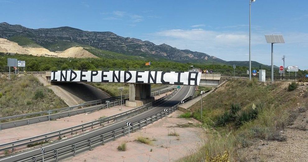 La pancarta que situada en els dies previs a la Diada al pont de la cimentera d'Alcanar, lluirà ara des de la serra del Montsià.