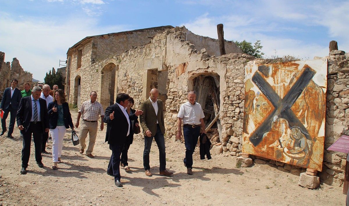 El conseller Raül Romeva, acompanyat d'autoritats locals, en la seua visita al Poble Vell de Corbera d'Ebre.