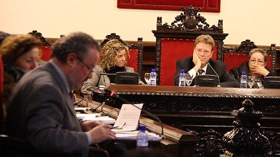 L'alcalde de Tortosa, Ferran Bel, al fons, durant la sessió plenària d'aquest dilluns, durant la intervenció del regidor del PP, Xavier Dalmau, en primer terme en una imatge d'arxiu