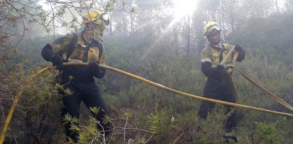 Dos bombers treballant el l'incendi de Calafell