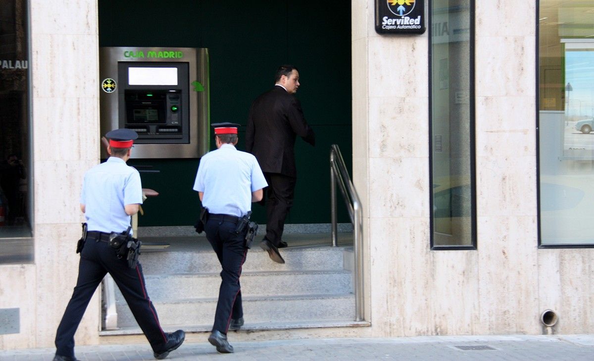 La comitiva judicial, amb el secretari al capdavant acompanyat per dos agents dels Mossos, entra a l'oficina de Caja Madrid (Bankia) a l'Avinguda Alcalde Palau d'Amposta, a finals de maig del passat 2013. 