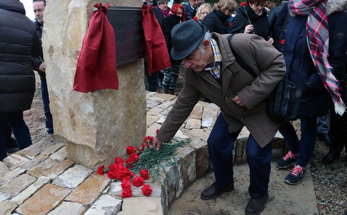 Un home posa un clavell roig al monument que commemora els Fets de la Fatarella el 28 de gener de 2017.