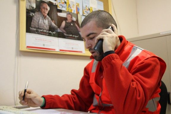 Voluntaris de la Creu Roja fent trucades a gent gran.