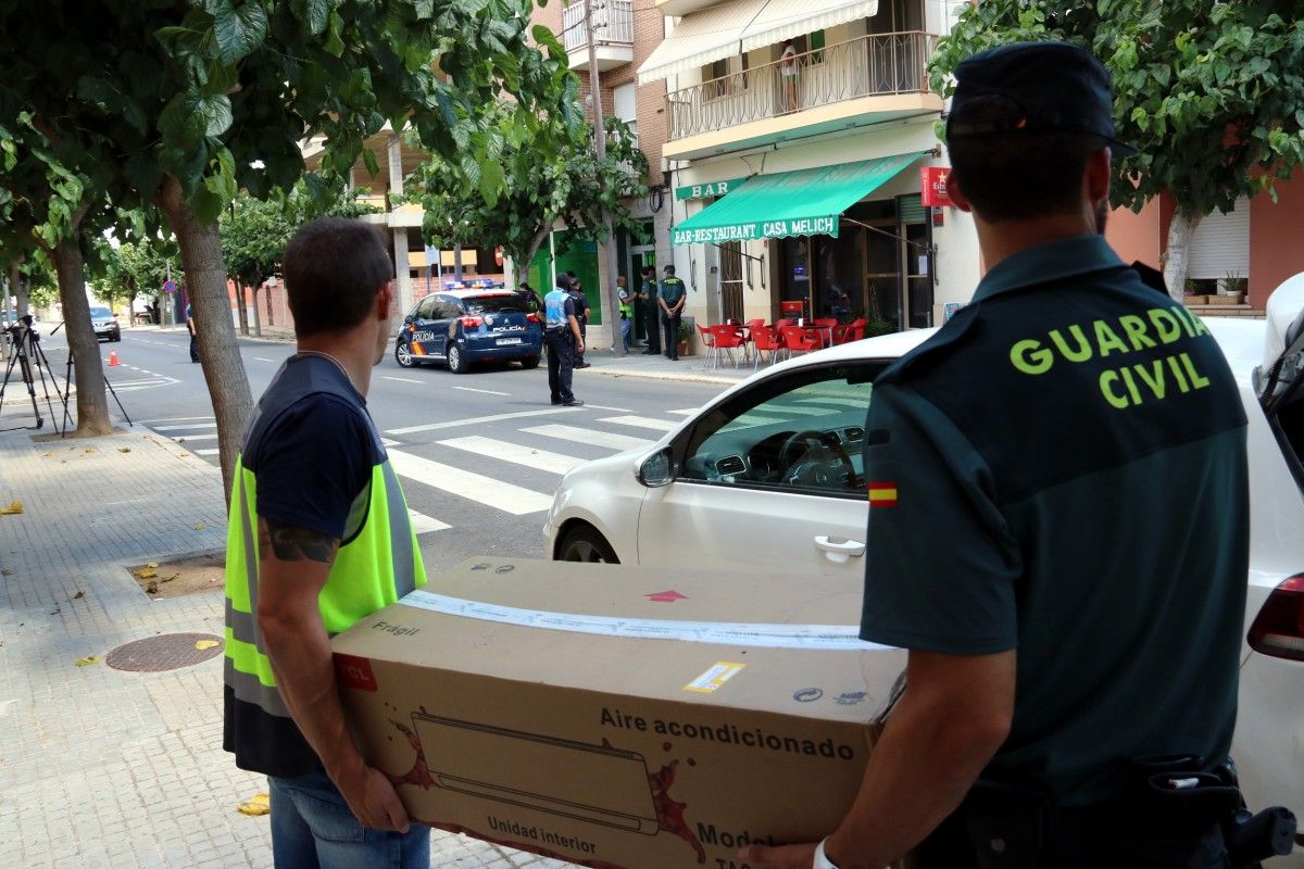 Dos agents de la Policia Nacional i la Guàrdia Civil transportant en una caixa de cartró material intervingut en l'operació antidroga