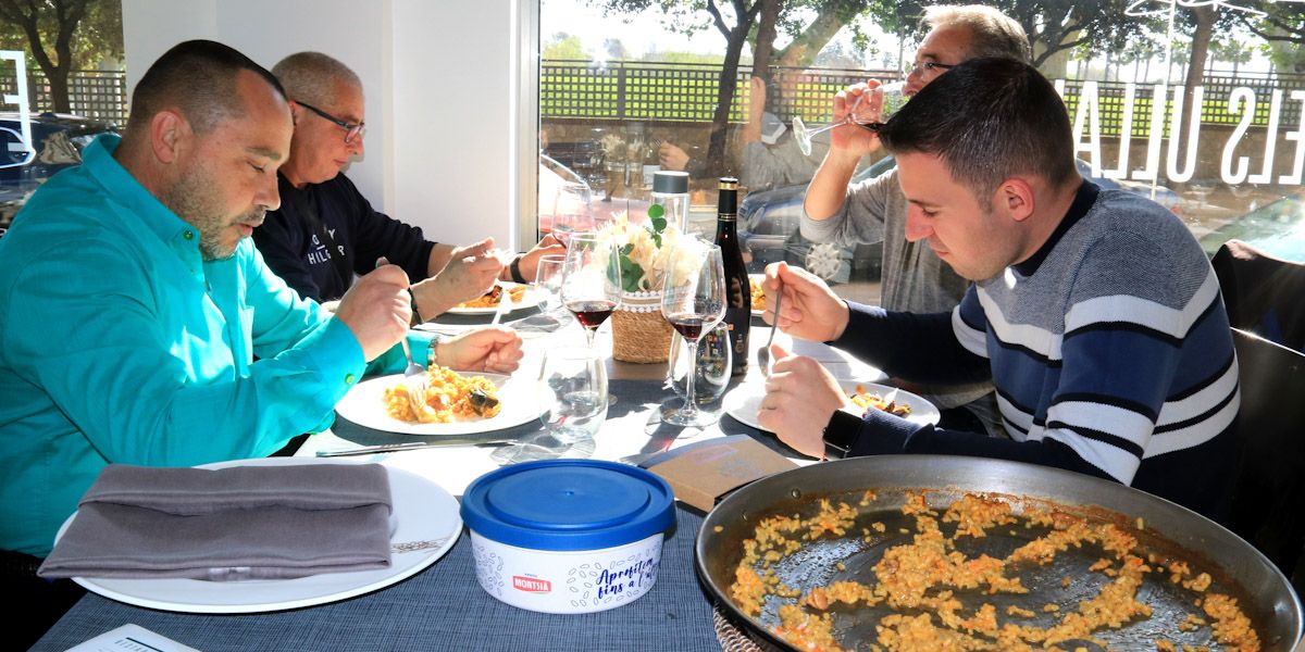 Un grup de clients dinen al restaurant Els Ullals d'Amposta al costat de la paella d'arròs i la carmanyola d'Oryzite de la Càmara Arrossera del Montsià amb què es podran endur el menjar