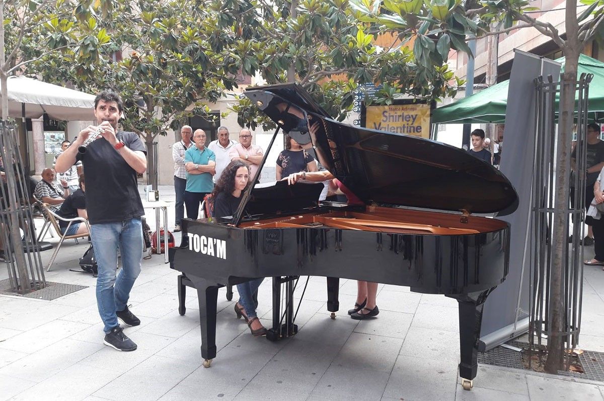 Una de les persones que s'ha atrevit a tocar el piano de cua instal·lat a la plaça de l'Àngel de Tortosa.
