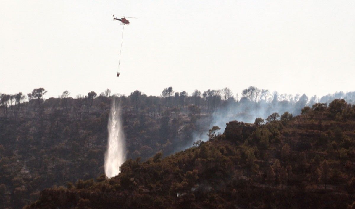Un helicòpter llençant aigua en la revifada d'un focus de l'incendi, entre els termes municipals de Bovera i Flix.