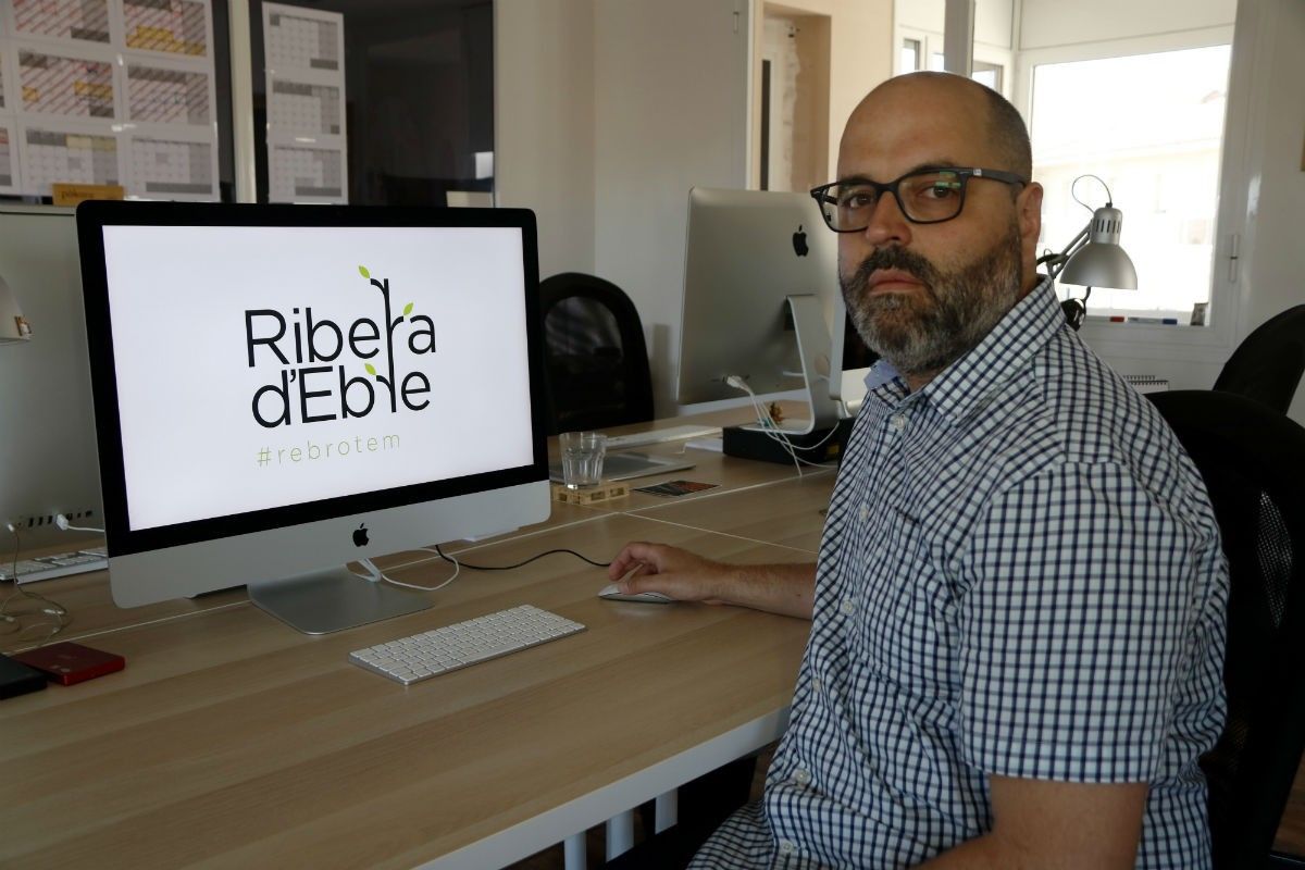 El dissenyador gràfic Daniel Rull al seu estudi del Morell amb la imatge que ha creat en solidaritat amb la Ribera d'Ebre.