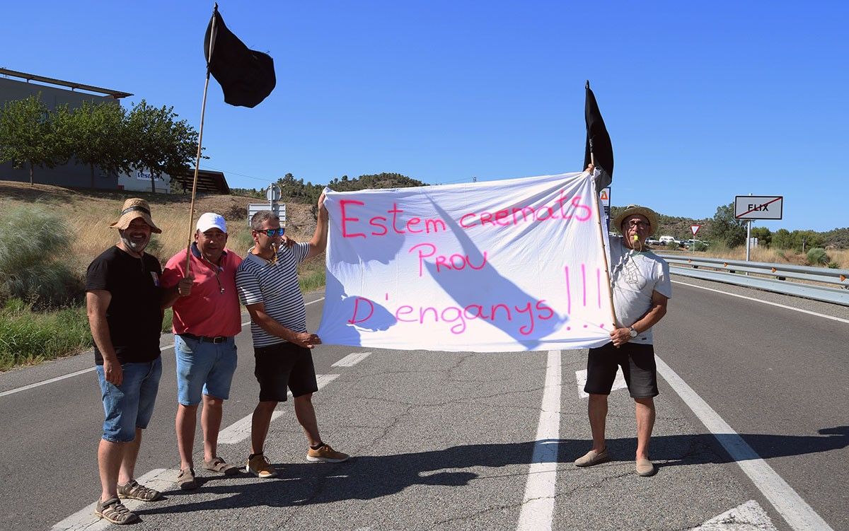 Manifestants amb una pancarta en el tall de carretera de la C-12 a Flix. 