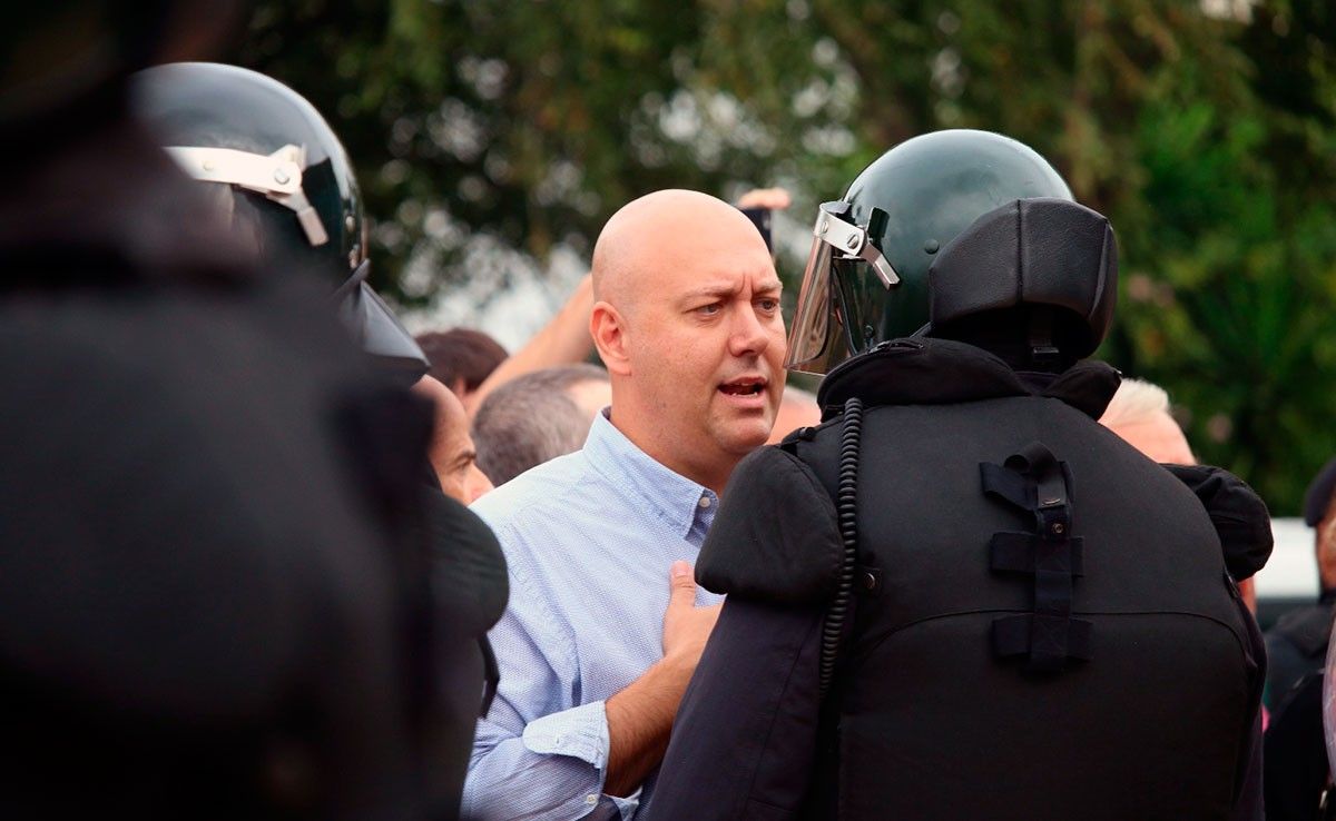 L'alcalde de la Ràpita, Josep Caparrós, davant un agent antiavalot de la Guàrdia Civil