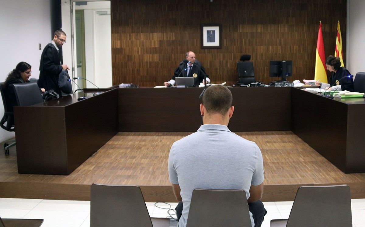 Andreu Curto, d'esquena, assegut durant el judici a la Ciutat de la Justícia, este dijous.