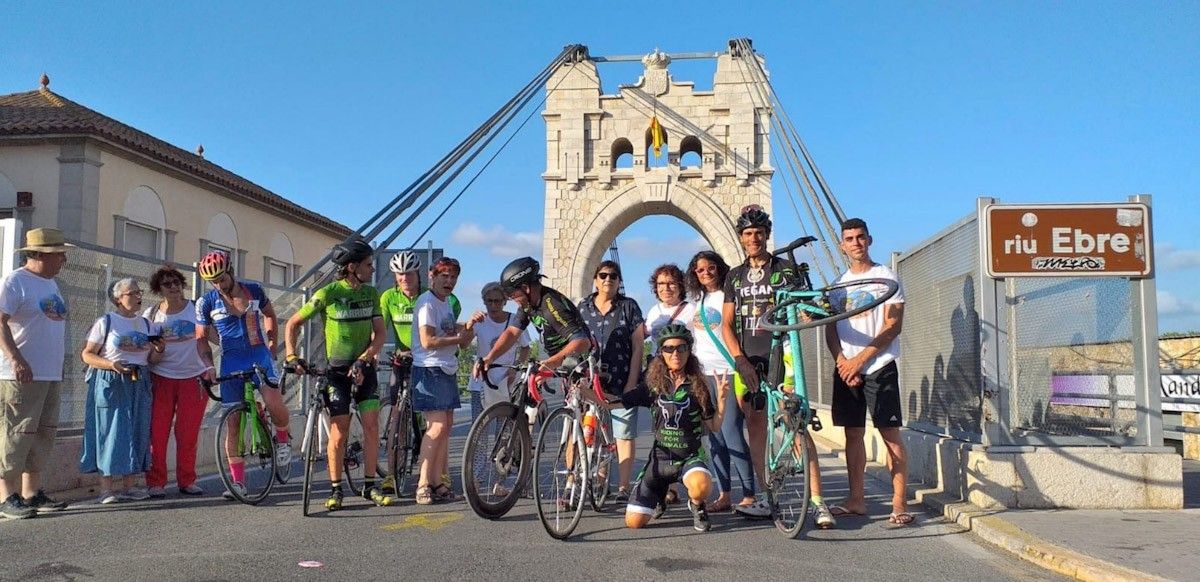 Membres de l'Associació d'Amposta "Tots som Poble"  van rebre als ciclistes  al pont penjat d'Amposta en un acte de benvinguda i de suport.