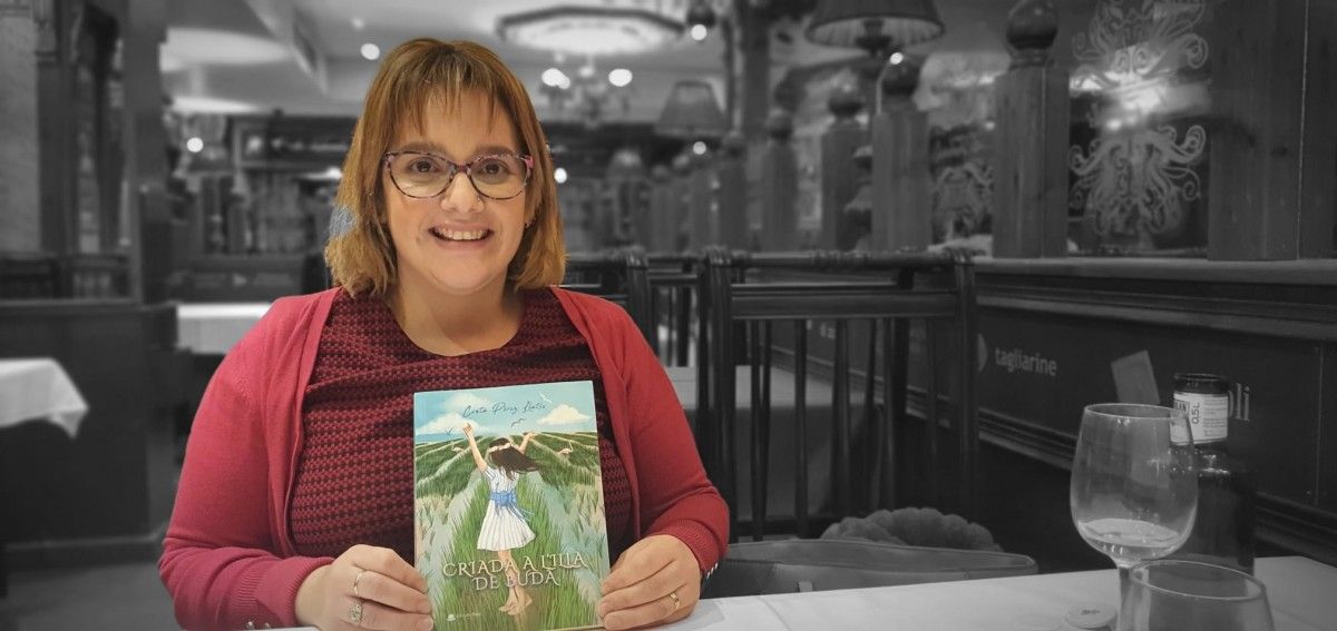 La periodista Cinta Pérez Llatse amb un exemplar del llibre 'Criada a Buda'