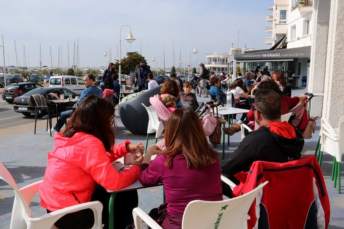 Persones consumint en una terrassa d'un bar de la zona marítima de l'Ampolla 